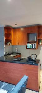 センチュリオンにあるLily's Innの木製のキャビネットとカウンタートップを備えたキッチン