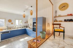 een keuken met blauwe kasten en een tafel en een stoel bij Kaz du Poete in Saint-Pierre +18 foto's