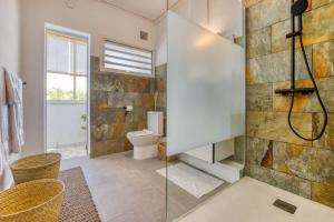 een badkamer met toilet en glazen douche bij Kaz du Poete in Saint-Pierre