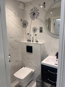 a bathroom with a toilet and a sink and a mirror at Paradise in Marston Green +17 photos