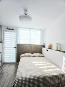 ein Schlafzimmer mit zwei Betten und einem großen Fenster in der Unterkunft El rincón zen- Suite independiente con baño privado y kitchenette in Torrevieja