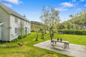 a picnic table on a deck next to a house at 200-Year-Old House By The Southern Archipelago in Mandal