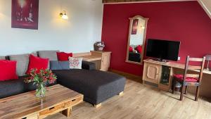 a living room with a couch and a tv at Hotel Leinsweiler Hof in Leinsweiler