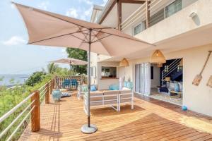 a patio with an umbrella on a deck at Villa Kap Grand Large in Saint-Leu +34 photos