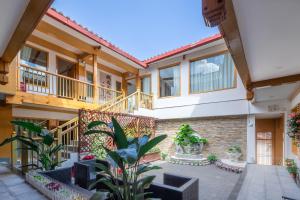 un patio de un edificio con sillas y plantas en Lijiang Tongfu Inn, en Lijiang
