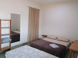 a small room with two beds and a mirror at Pousada Zero Três - 03 in Chapada dos Guimarães +29 photos