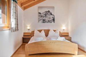a bedroom with a large bed with white pillows at Skiblickhaus in Russbach am Pass Gschütt