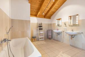 a bathroom with two sinks and a tub and a toilet at Skiblickhaus in Russbach am Pass Gschütt +33 photos