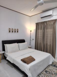 a bedroom with a bed with a brown towel on it at Seven Stones Langkawi in Pantai Cenang +29 photos