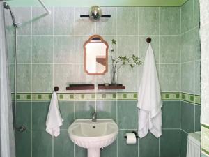 ein grün gefliestes Bad mit einem Waschbecken und einem Spiegel in der Unterkunft Luxury 5-Bedroom Villa Sarcon 88 on seaside in Karaoğlanoğlu + 90 Fotos