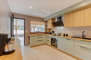 een keuken met witte kasten en een groot raam bij Kaz Nautilia in La Saline Les hauts 