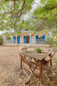 een houten picknicktafel voor een gebouw bij Kaz Nautilia in La Saline Les hauts 