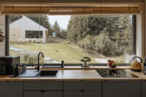 a kitchen with a window with a view of a field at Wood Rest, MyWeek in Stronie Śląskie