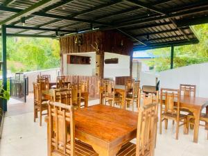 a dining room with wooden tables and chairs at Cloudora Inn Kandy in Kandy