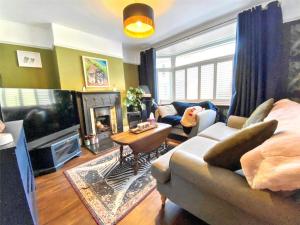 a living room with a couch and a tv at Drew Street Digs in Brixham