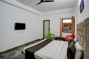 une chambre avec un lit et une télévision au mur dans l'établissement Super Hotel O Omi Rooms, à Gurgaon