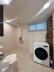 een badkamer met wasmachine en toilet bij LUMI Stay in Gyeongju