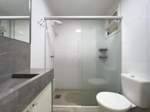 a bathroom with a toilet and a glass shower at Vista espetacular beira mar - Capão da Canoa in Capão da Canoa +17 photos