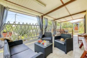 a living room with chairs and a table and a large window at Kaz Santa Maria in Saint-Leu