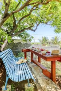 a picnic table and bench under a tree at Kaz Santa Maria in Saint-Leu