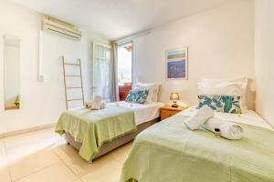 two beds in a room with a window at Kaz Santa Maria in Saint-Leu