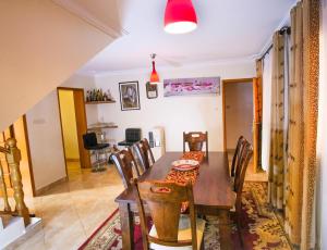 une salle à manger avec une table et des chaises en bois dans l'établissement Tara Villa - Elegant 4-Bedroom Home in Buziga - Kampala, à Kampala 9 autres photos
