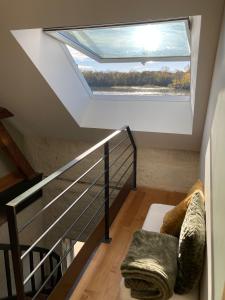 une lucarne dans une cage d'escalier avec une fenêtre dans l'établissement Chambres privées au dessus du restaurant Nuances, à La Chapelle-sur-Loire