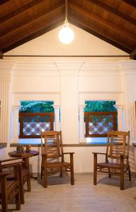 zwei Stühle und ein Tisch und zwei Fenster in der Unterkunft Chali' Villa in Matale