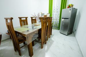 einen Esstisch mit Stühlen und einen Kühlschrank in der Unterkunft Chali' Villa in Matale