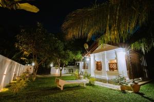 ein Haus mit einer Bank im Hof bei Nacht in der Unterkunft Chali' Villa in Matale