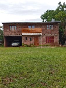 a brick house with a car in the garage at Serendipia in Oberá