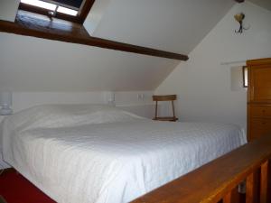 une chambre avec un lit blanc et une fenêtre dans l'établissement La Maison du Sabotier, à Corancy