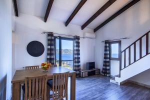 een eetkamer met een tafel en uitzicht op de oceaan bij Casa Anna-Maria in Saint-Florent +18 foto's