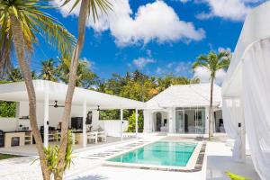 an exterior view of a villa with a swimming pool and palm trees at Villa Piano - Luxury 3BR Villa with, Sauna, Ice bath & Outdoor cinema in Ubud