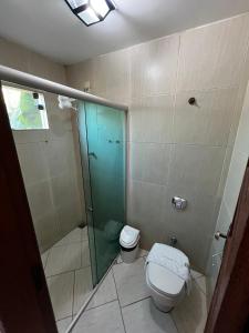 a bathroom with a toilet and a glass shower at Pousada Recanto dos Cisnes in Betim