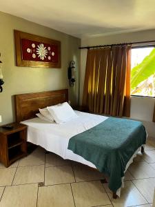 a bedroom with a white bed and a window at Pousada Recanto dos Cisnes in Betim +4 photos
