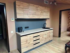 a kitchen with wooden cabinets and a counter top at Готель-ресторан Chalet in Bila Tserkva +28 photos