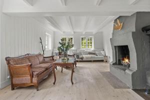 a living room with a couch and a fireplace at 200-Year-Old House By The Southern Archipelago in Mandal