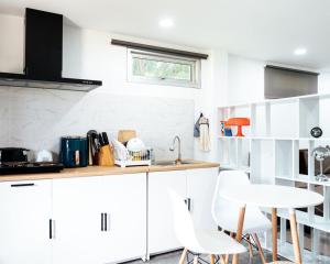 a kitchen with white cabinets and a table and chairs at Apollo Hotel Chalong in Ban Suan