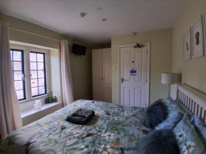 a bedroom with a bed with a floral bedspread at The Grove Arms 