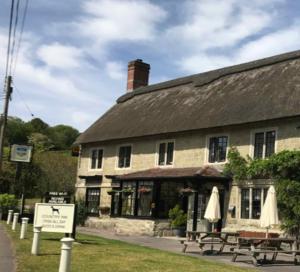 an old stone building with a table and umbrella at The Grove Arms 