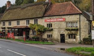a stone building with a sign that reads the grape vines at The Grove Arms 