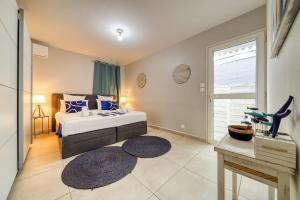 a bedroom with a bed and a large window at Kaz d Abord in Saint-Pierre