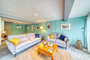 a living room with two couches and a table at Kaz d Abord in Saint-Pierre