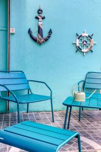 three blue benches next to a wall with a nautical sign at Kaz d Abord in Saint-Pierre +26 photos