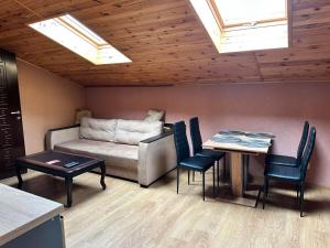 a living room with a couch and a table and chairs at Готель-ресторан Chalet in Bila Tserkva