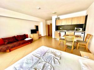 Una sala de estar con una cama y una cocina. en Grand Kamelia apartments, en Sunny Beach