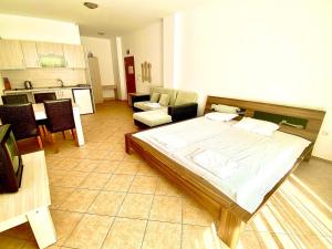 Un dormitorio con una cama grande y una cocina. en Grand Kamelia apartments, en Sunny Beach