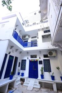 un edificio blanco con puertas azules y macetas en White Poppy Lake Side Hostel, en Udaipur