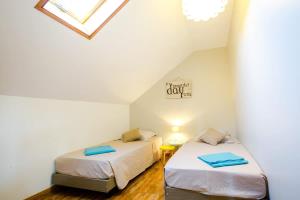 two beds in a small room with a skylight at Kaz Combava in Étang-Salé
